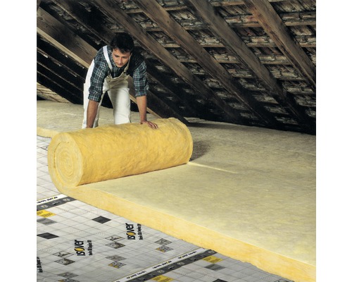 Un homme pose de la laine isolante dans un grenier pour l''isolation thermique.