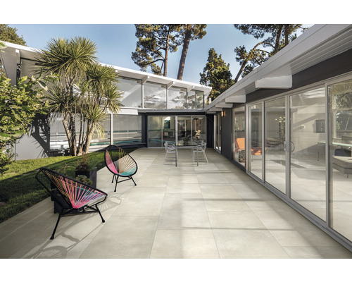 Terrasse mit Gartenmöbeln vor modernem Haus mit Schiebetüren