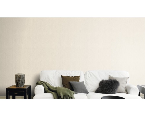 Wohnzimmer mit weißem Sofa, Kissen und beiger Tapete