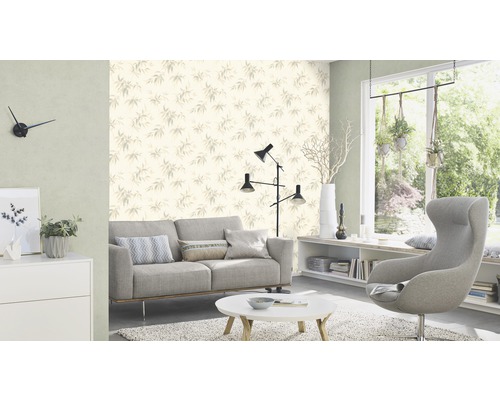 Salon avec canapé, fauteuil, table et papier peint à motif de feuilles pour une atmosphère lumineuse et organisée.