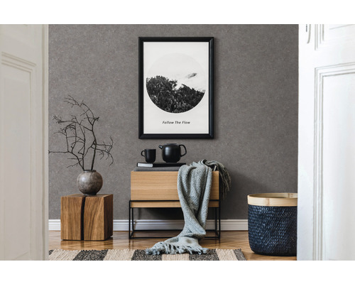 Dekoratives Zimmer mit grauer Tapete, Holzmöbeln und einem gerahmten Bild an der Wand.