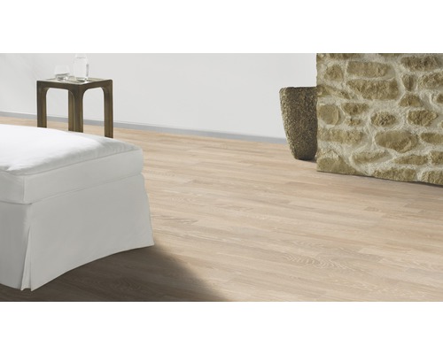 Heller Laminatboden in einem Wohnraum mit Sofa, Tisch und Steinwand