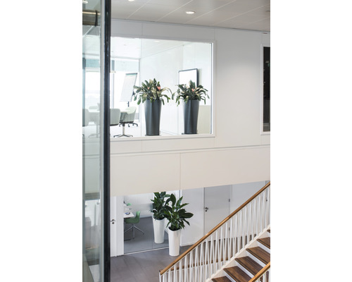 Innenaufnahme eines Treppenhauses mit Topfpflanzen auf verschiedenen Ebenen.