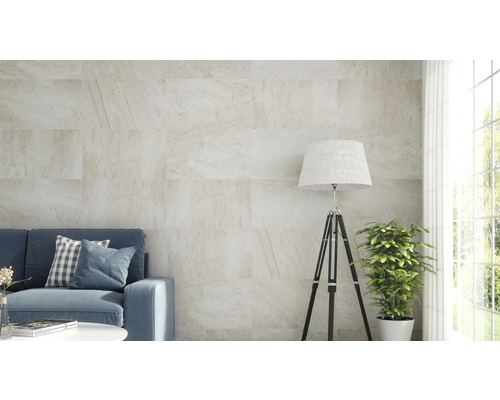 Wohnzimmer mit Sofa und Wandfliesen in Steinoptik.