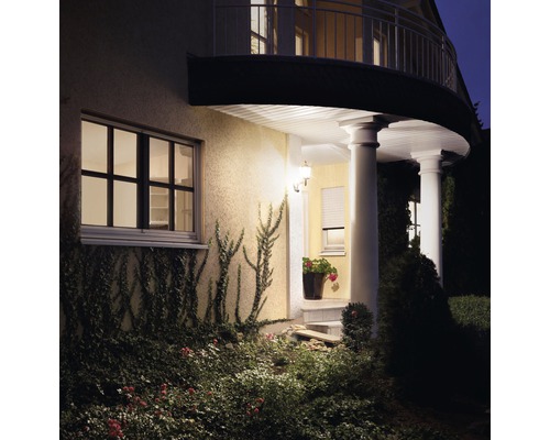 Maison d''habitation éclairée avec jardin dans l''obscurité.