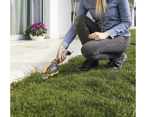 Frau schneidet Rasenkanten mit einer Akku-Grasschere der Marke Stiga
