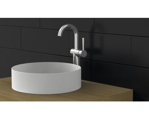 Aufsatzwaschbecken mit Armatur auf Waschtischplatte vor dunkler Wand