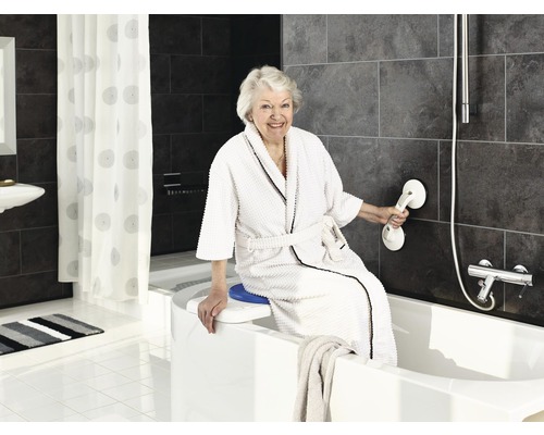 Frau in einem Badezimmer mit Badewannenlifter und Haltegriff