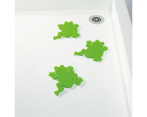 Trois autocollants antidérapants grenouilles vertes dans une douche.