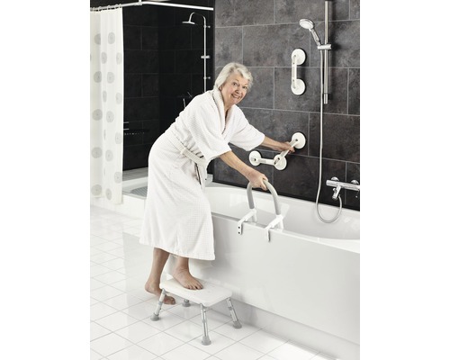 Femme en peignoir avec échelle de bain, marchepied et barres d''appui dans la salle de bain