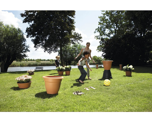 Szene im Garten mit spielenden Kindern und Pflanzgefäßen.