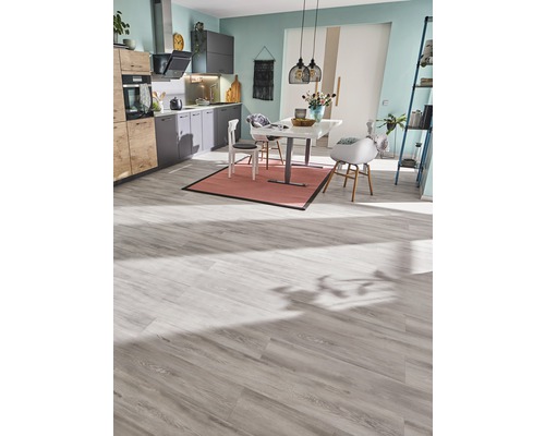 Cuisine claire avec table à manger, chaises et sol stratifié.