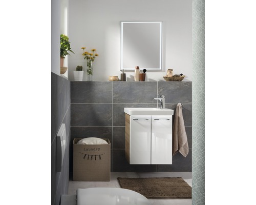 Salle de bain avec meuble-lavabo, miroir, serviette et panier à linge