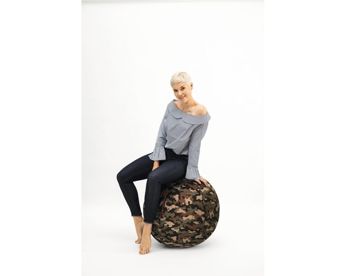 Femme assise sur un ballon de gymnastique à motif camouflage