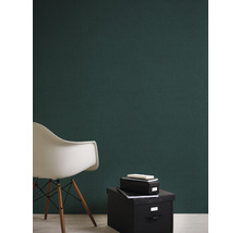 Scène avec un mur vert, une chaise blanche et des boîtes de rangement noires