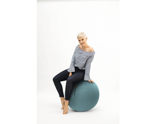 Une femme assise sur un ballon de gymnastique comme siège.