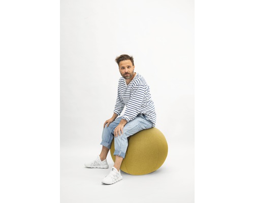 Un homme est assis sur un ballon de gymnastique