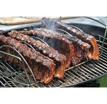 Travers de porc dans un support à ribs sur un gril