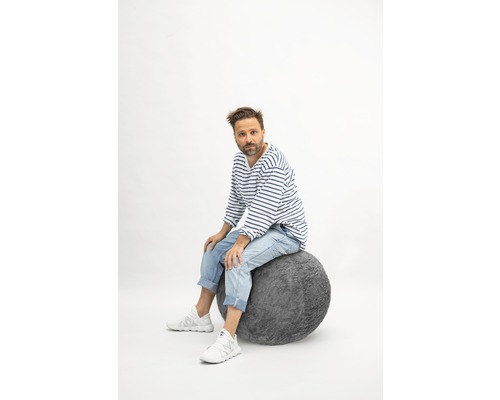 Homme assis sur un ballon d''assise gris