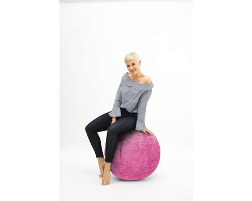 Femme assise sur un ballon de gymnastique rose