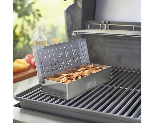 Grill mit Räucherbox auf Grillrost gefüllt mit Räucherholz