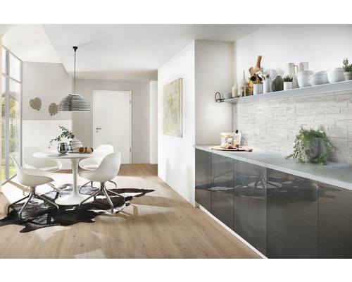 Salon lumineux avec table à manger, chaises, comptoir de cuisine et décoration murale