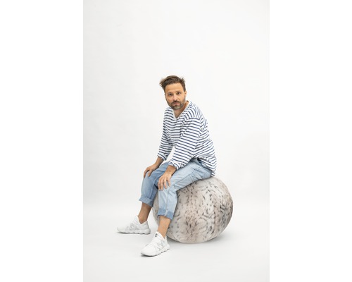 Homme assis sur un ballon de siège avec motif de fourrure