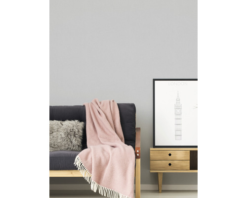 Wohnzimmer mit Sofa, Kissen, Decke und Kommode