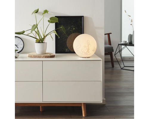 Lampe de chambre décorative sur une commode à tiroirs, avec une plante d''intérieur et une photo encadrée