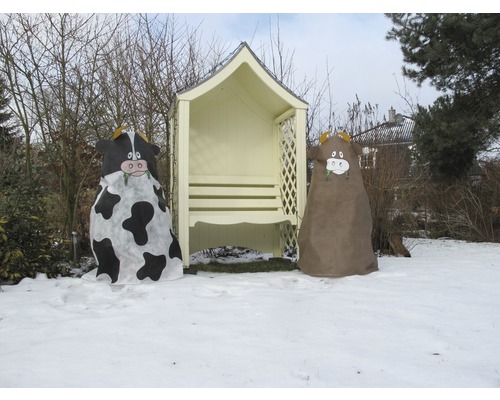 Szene im Garten mit Pflanzenschutzhüllen in Kuhform und einer Gartenlaube im Winter