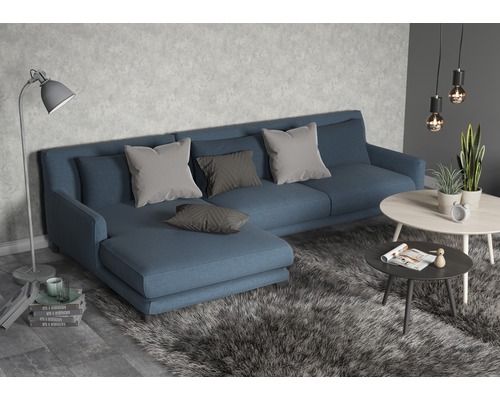 Salon avec canapé bleu, coussins et tables basses sur un tapis