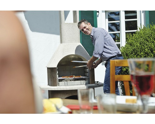 Un homme fait griller des aliments à l''extérieur avec un barbecue de jardin