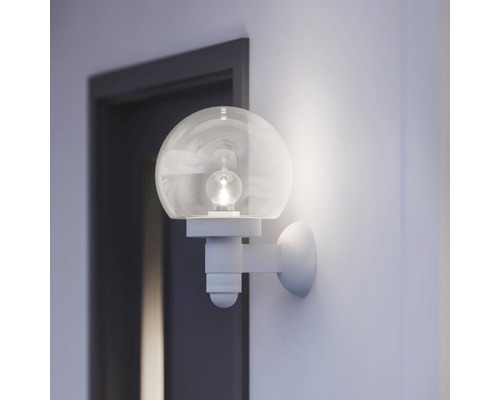 Applique murale avec globe en verre rond dans une pièce lumineuse à côté d''une porte