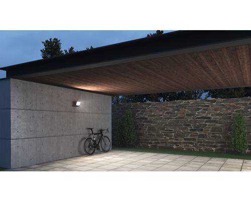 Espace extérieur avec mur en béton, vélo, mur en pierre et éclairage extérieur