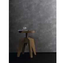 Dekorative Szene mit Holzhocker, Buch und Tasse vor einer grauen Wand