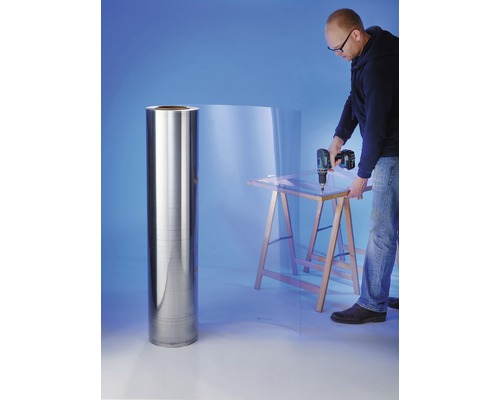 "Mann bohrt in eine transparente Kunststoffplatte