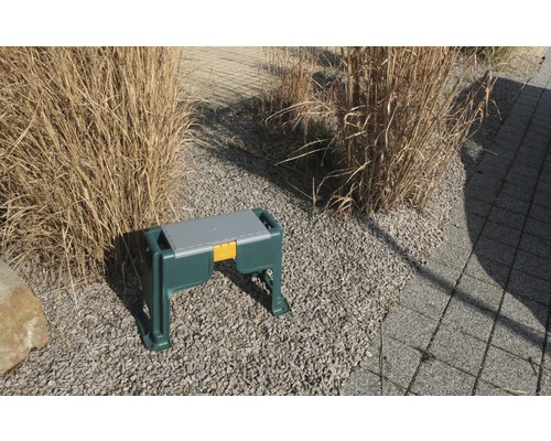 Tabouret de jardin avec espace de rangement sur sol en gravier dans le jardin