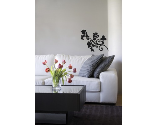 Salon avec canapé blanc, table basse, vase de fleurs et décoration murale