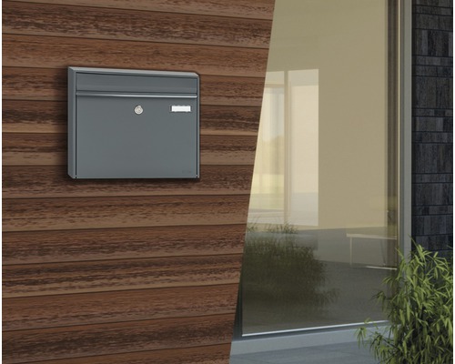 Boîte aux lettres grise sur mur en bois