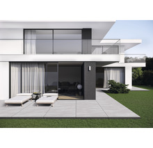 Maison moderne à deux étages avec terrasse, mobilier de jardin et pelouse