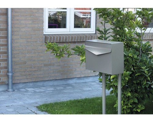 Boîte aux lettres en métal sur deux poteaux dans le jardin devant