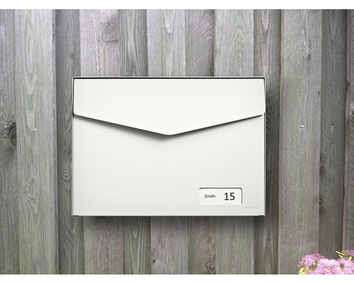 Rechteckiger Briefkasten mit Namensschild und Hausnummer an Holzwand