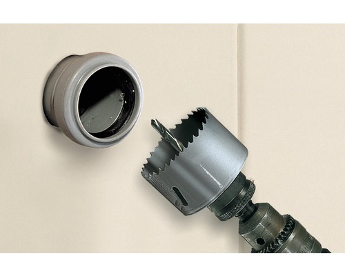 Scie cloche sur une perceuse à côté d''une traversée de mur