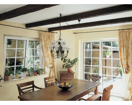 Salle à manger avec table en bois, chaises, fenêtres et rideaux