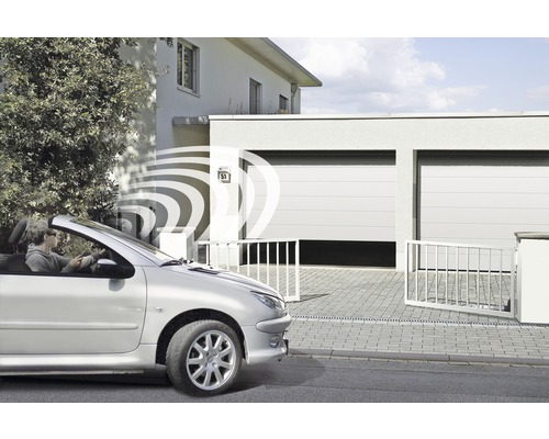 Une personne ouvre la porte du garage par signal radio depuis la voiture