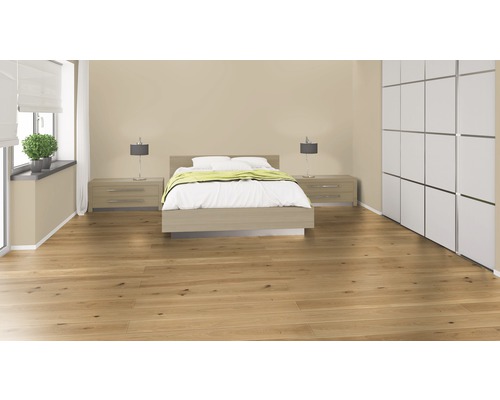 Helles Schlafzimmer mit Holzboden, Doppelbett, Nachttischen, Lampen, Vorhängen und Schrank.