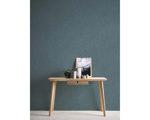 Console en bois clair avec décoration et image devant un mur texturé