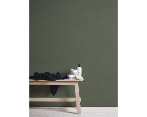 Scène avec un banc en bois, une serviette et des articles de salle de bains devant un mur