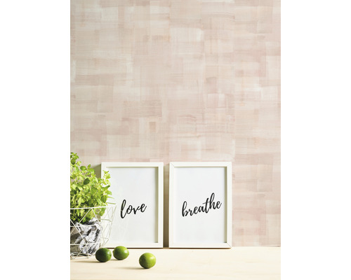 Dekorative Szene mit zwei gerahmten Schriftbildern, einer Pflanze im Korb und Limetten