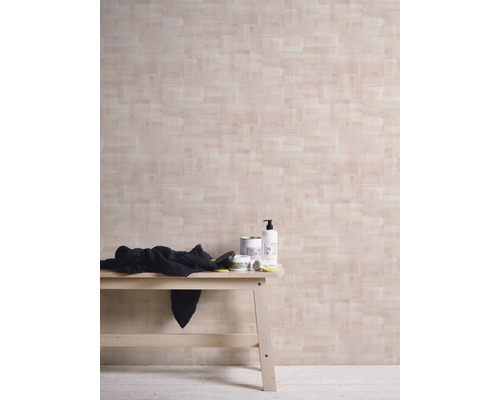 Helle Holzbank mit Pflegeprodukten vor einer Wand mit Holzoptik Tapete